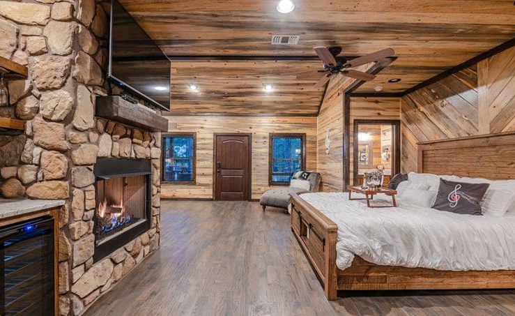 harmony in the pines bedroom area with fireplace, tv, and king bed