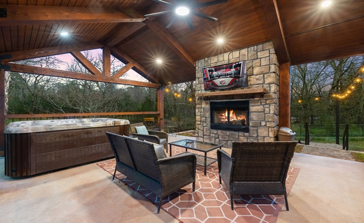 covered porch with hot tub fireplace and seating